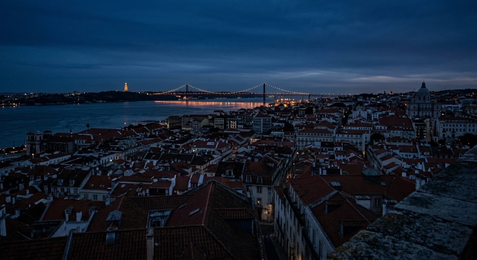 Los tejados de Lisboa al anochecer, con el río Tajo al fondo